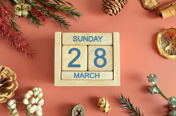 March 28, Cover design with calendar cube, pine cones and dried fruit in the natural concept.