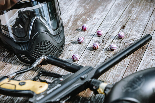 Close up of an equipment for action paintball game, protective mask, gun and ball bullets