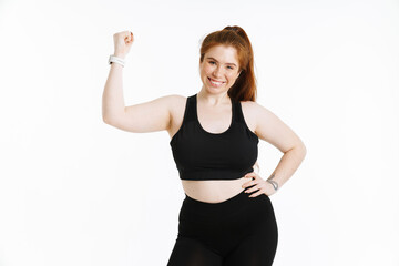 Young ginger woman smiling while showing her bicep