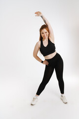 Smiling young plus size fitness woman in sportswear