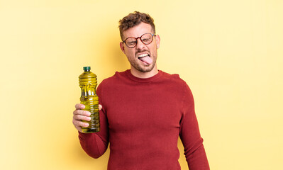 young handsome man with cheerful and rebellious attitude, joking and sticking tongue out. olive oil...