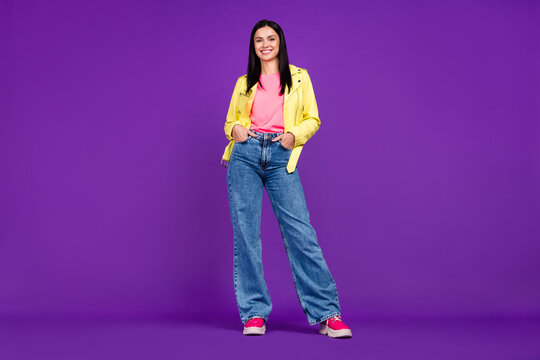 Full size photo of young cheerful lady arms in pocket cool standing isolated over violet color background
