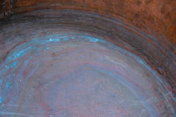 Oxidized copper old cauldron with plum hues. Aqua color circles on the bottom. Copy space.