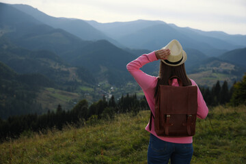 Fototapeta na wymiar Woman enjoying mountain landscape, back view. Space for text
