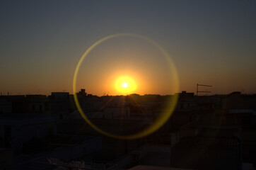 Fotografia di un tramonto con alone circolare riflesso.