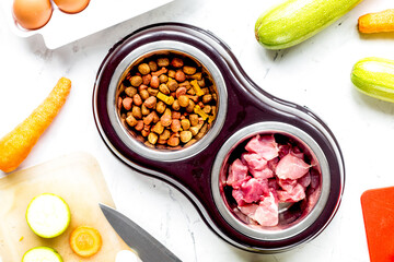 Dogfood set with cut vegetables and knife on table background top view