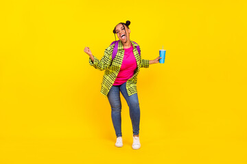 Fototapeta na wymiar Full body photo of cheerful afro american woman wear backpack hold drink winner isolated on yellow color background