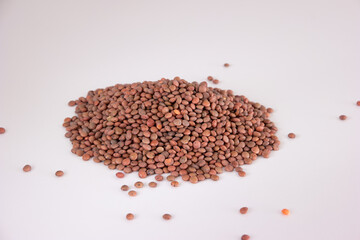 Raw uncooked lentils pile on white background, top view, no people