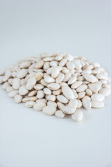 Raw uncooked white kidney beans pile on a white background, top view, no people