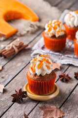 Homemade autumn pumpkin cupcakes or muffins with nuts and spices