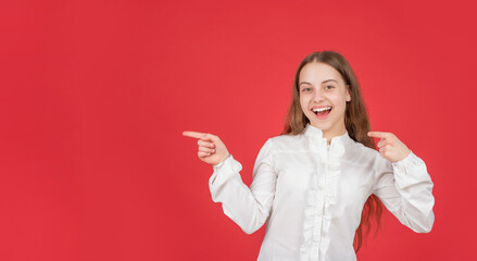 teen girl with happy face pointing finger on copy space. back to school. advertisement concept.