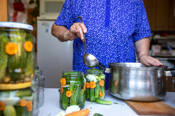 Process of homemade canning fresh, bio cucumbers to a jars by senior woman, food concept