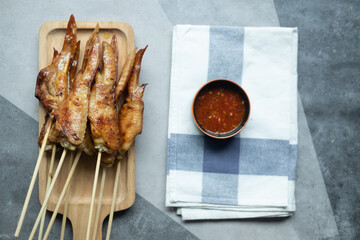 Grilled chicken wing in bamboo stick dipping with Jaew