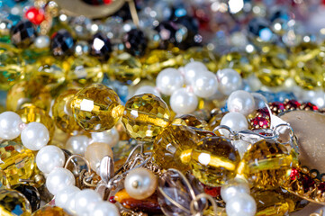 necklaces, earrings, bracelets, pearls, beads and various colored gemstones as a background