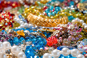 necklaces, earrings, bracelets, pearls, beads and various colored gemstones as a background
