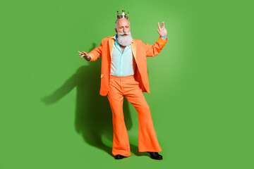 Full length body size view of attractive elegant funky grey-haired man dancing wearing crown isolated over bright green color background