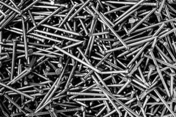 A pile of nails in black and white. Close up of the mess in the toolbox.