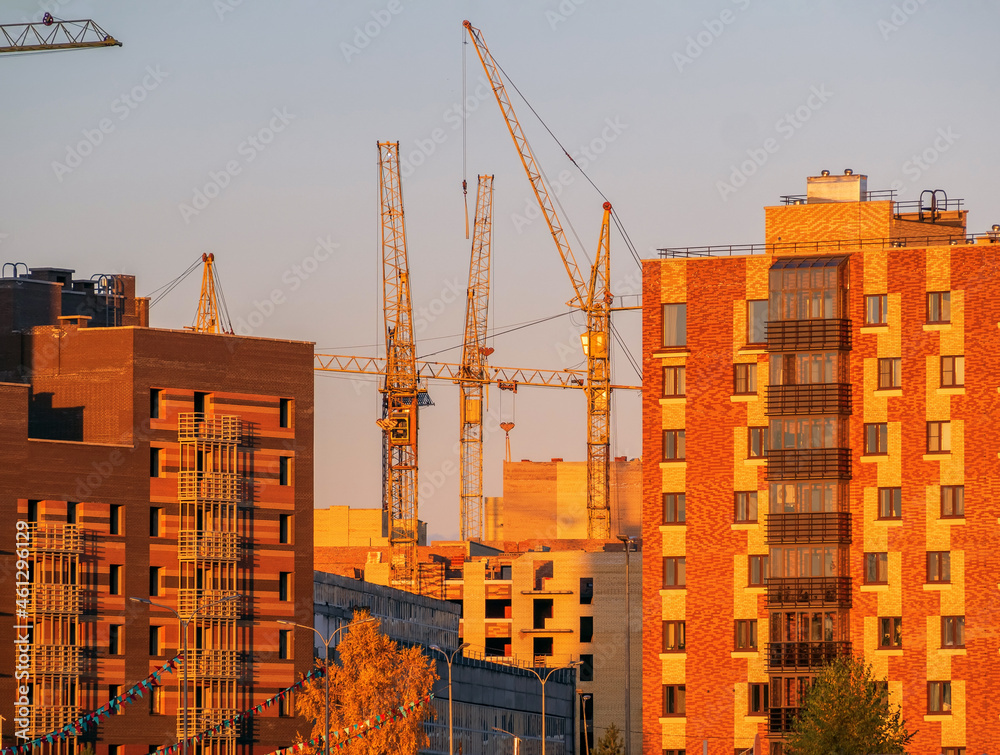 Wall mural construction of a skyscraper in an urban environment. construction industry. evening photo.