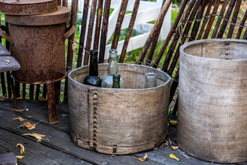 still life with a wooden table and old bottles on it against the background of the autumn sky 