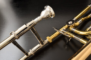 Detail of mouthpiece and mechanism of trombone on black