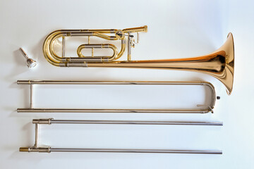 Fototapeta na wymiar Trombone with transposer disassembled on a white table top view