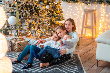 Happy kids near the Christmas tree with the present boxes