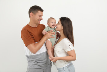 Portrait of happy family with their cute baby on white background