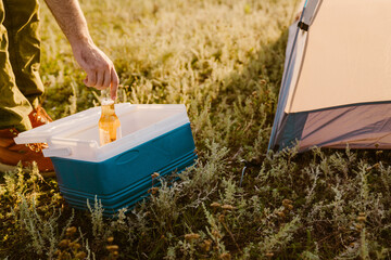 White man drinking bear during camping on summer day