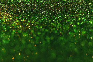 Green and golden sparkling glitter bokeh background, christmas abstract defocused texture. Holiday lights