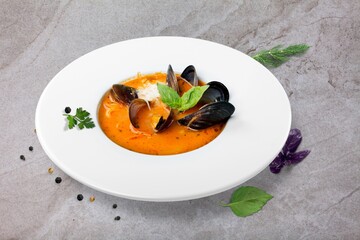 Mixed tasty seafood in plate on a gray stone background. Raw Shrimp, mussels and scallops