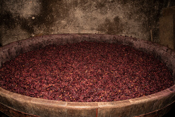 Grapes fermentation in a wooden barrel.wine making process - fermented grape before pressing