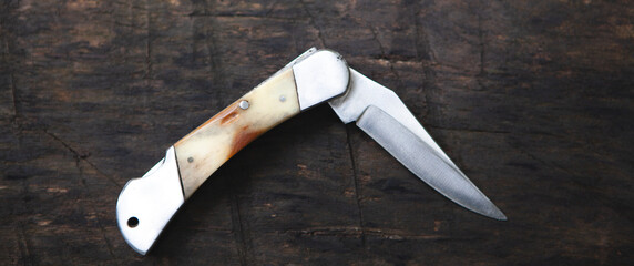 folding knife on an old brown board
