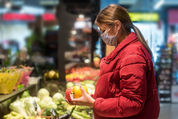 Girl wears protected mask in store. Shopping time during coronavirus outbreak. Girl in a medical mask. Quarantine and protection virus, flu, epidemic COVID-19. Coronavirus quarantine.