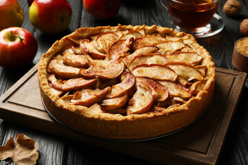 Delicious apple pie on black wooden table