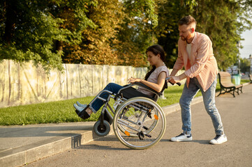 Fototapeta na wymiar Family couple with wheelchair overcomes the curb