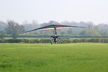 Obraz na płótnie Canvas Ultralight airplane taking off from a farm strip 