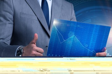Businessman holding screen with market quotes