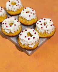 Homemade keto dessert donuts made from almond flour glazed with whipped cream. Gluten-free, low-carb baked goods.