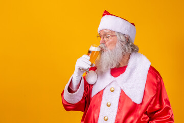 Santa Claus drinking a glass of beer. Rest time. Alcoholic drink at the holidays. Drink with...