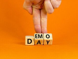 Demo day symbol. Businessman turns wooden cubes with concept words 'demo day' on a beautiful orange...