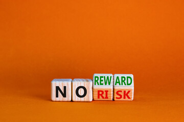 No risk or reward symbol. Turned cubes and changed words 'no risk' to 'no reward'. Beautiful orange background. No risk or reward and business concept. Copy space.