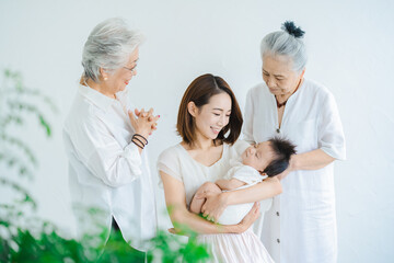 Fototapeta premium 赤ちゃんを抱っこするお母さんと2人のシニア女性