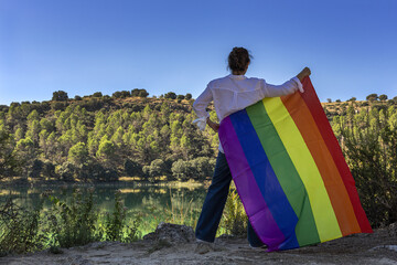 Middle-aged lesbian woman holding the Gay Rainbow Flag