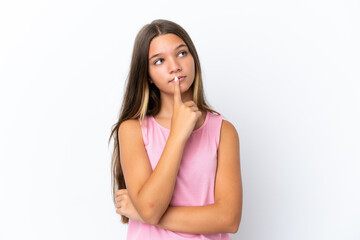 Little caucasian girl isolated on white background having doubts while looking up