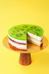 Sliced Birthday cake on the wooden cake stand. Beautiful sponge cake on the paper background. Copy...