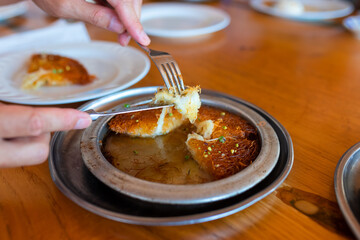 Turkish dessert kunefe, kunafa, kadayif with pistachio powder and cheese, served hot, very sweet.