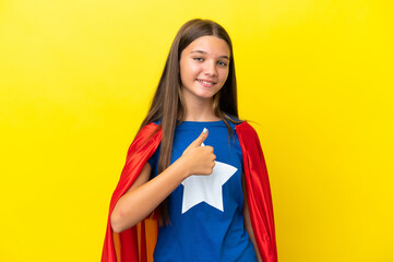 Little caucasian superhero girl isolated on yellow background giving a thumbs up gesture