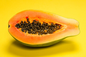 Papaya fruit on a yellow background. Tropical fruit.