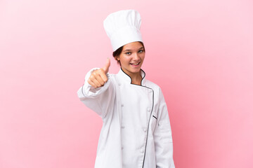 Little caucasian chef girl isolated on pink background with thumbs up because something good has happened