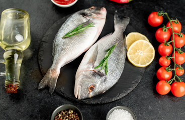 raw dorado fish with lemon and rosemary on stone background